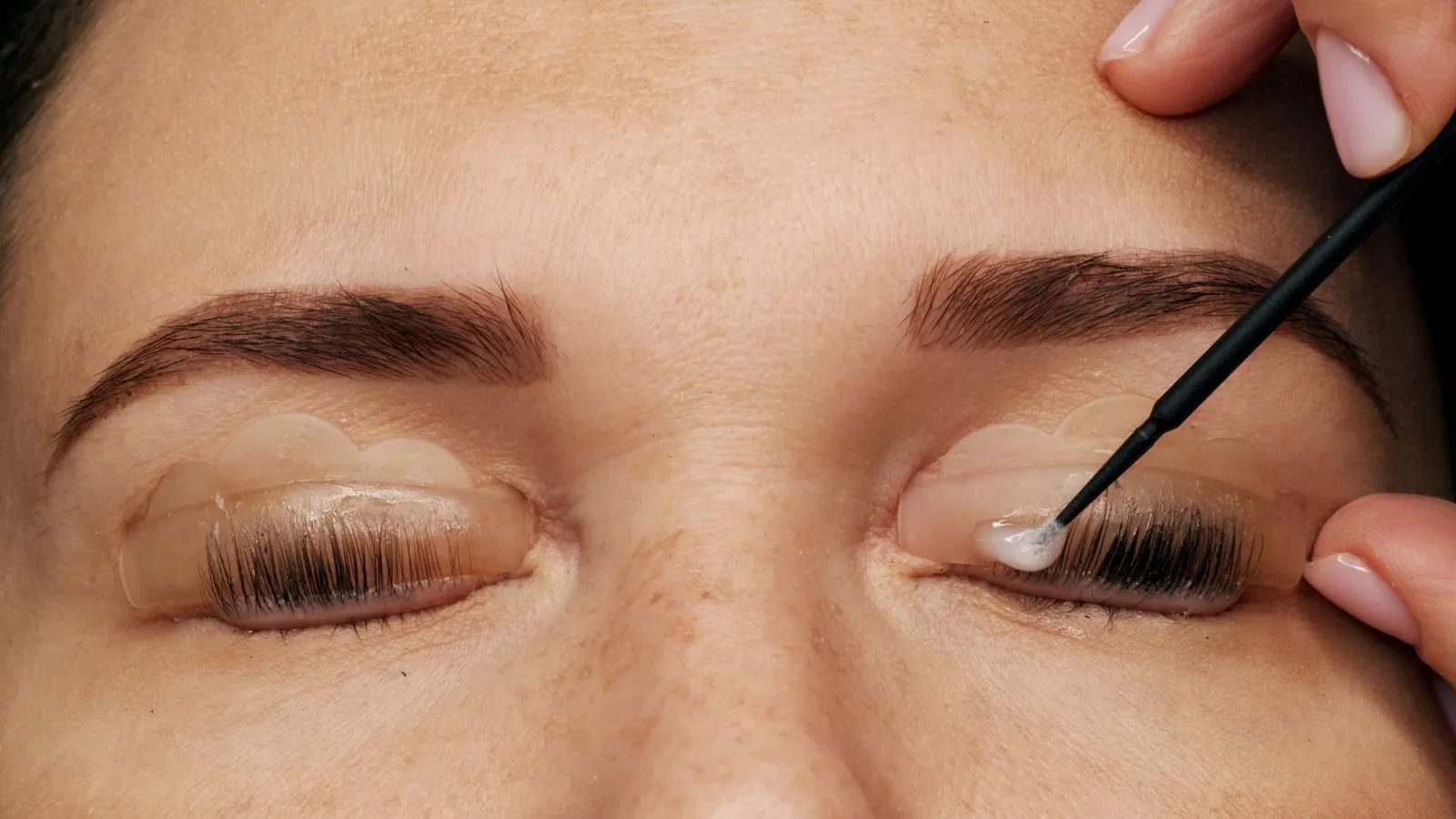 Wimpern werden bei der Laminierung mit einem Bürstchen aufgerichtet