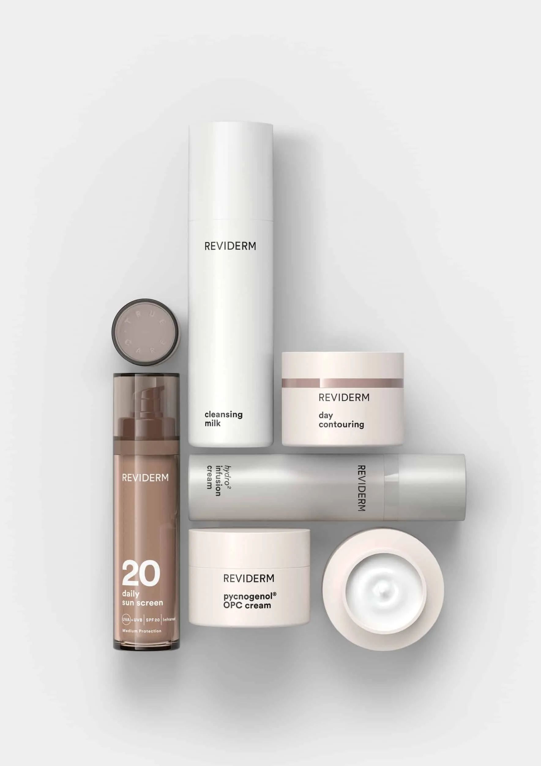 Produktgruppe von REVIDERM: Reinigungsmilch, Tagescreme, Serum und weitere Tiegel und Flaschen